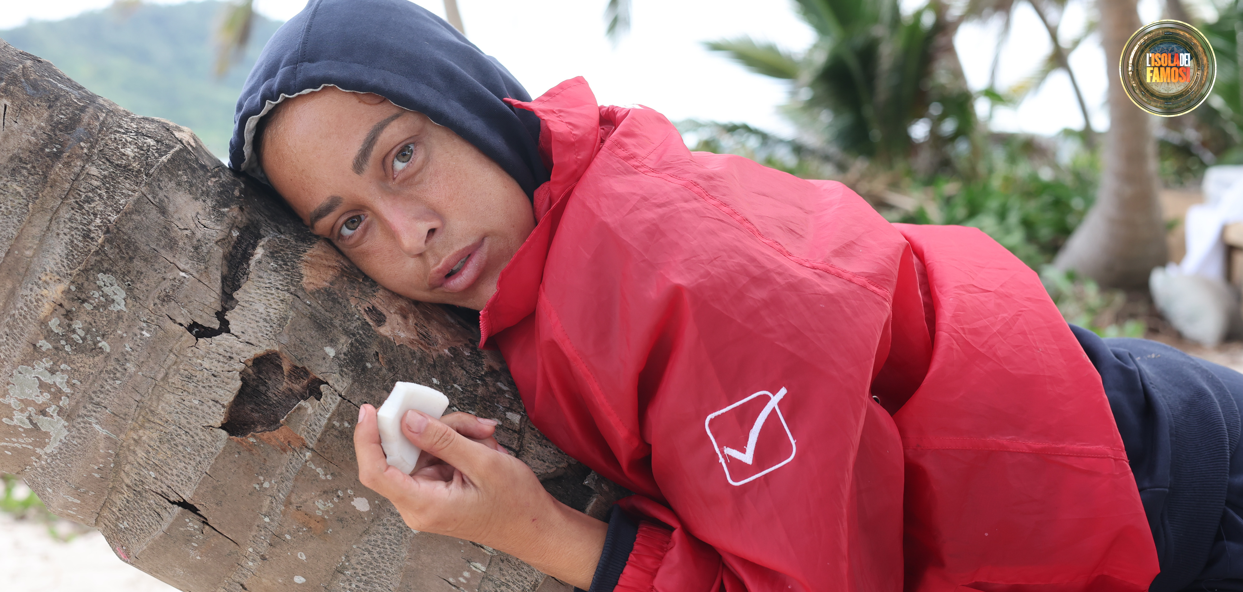 Distesa su un tronco, Teresanna mangia la sua porzione di cocco.