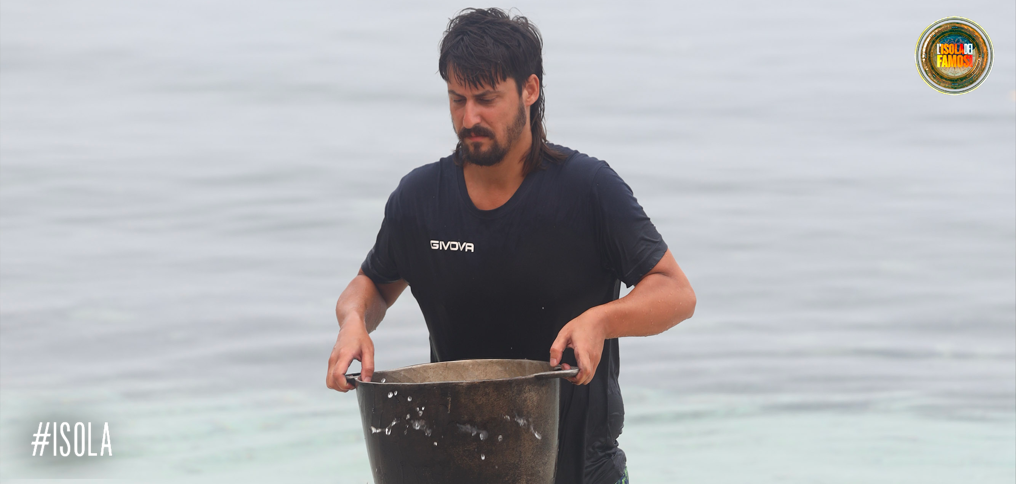 Edoardo Franco riempie la pentola d'acqua di mare per poter cucinare il riso.