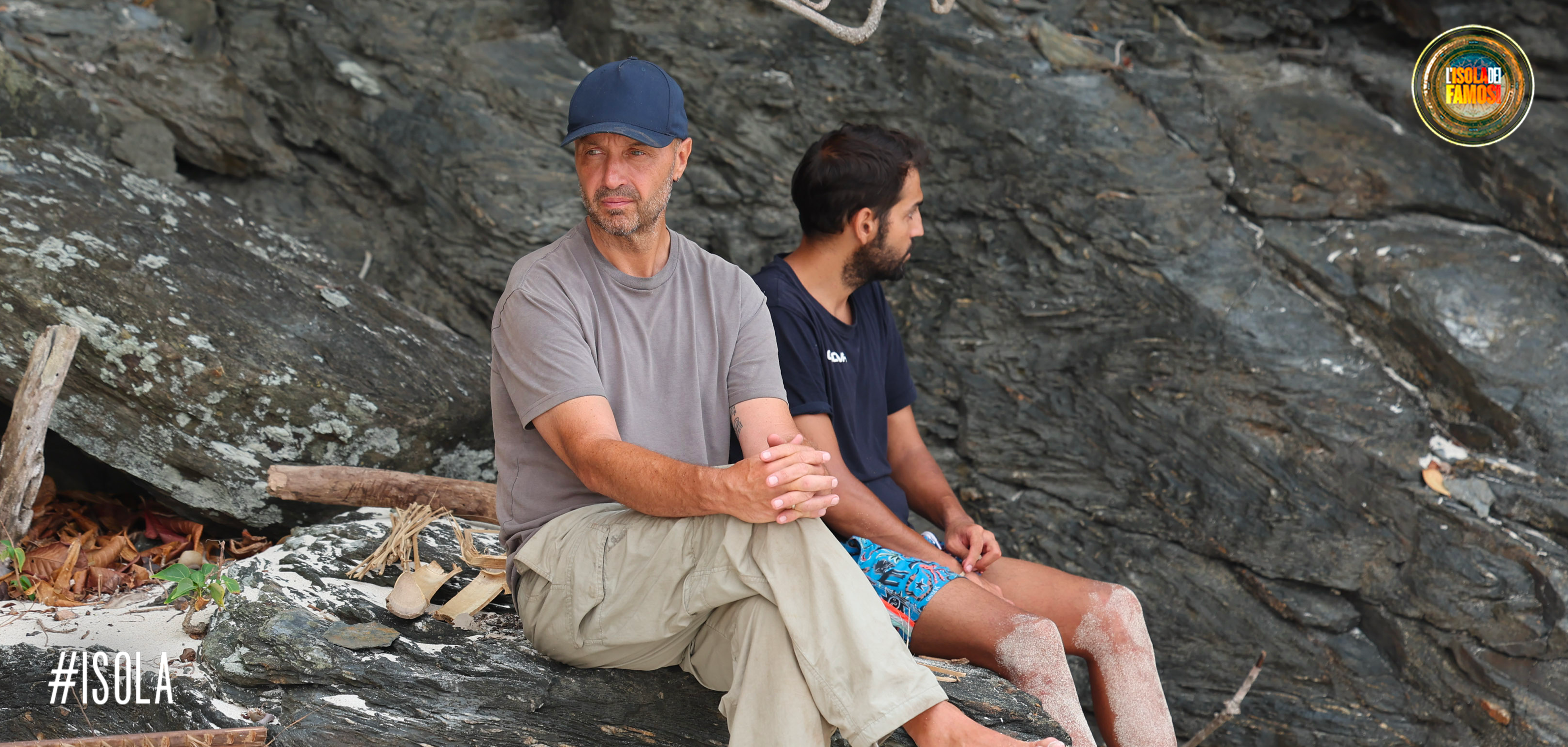 Joe Bastianich seduto su uno scoglio come se fosse al bar.