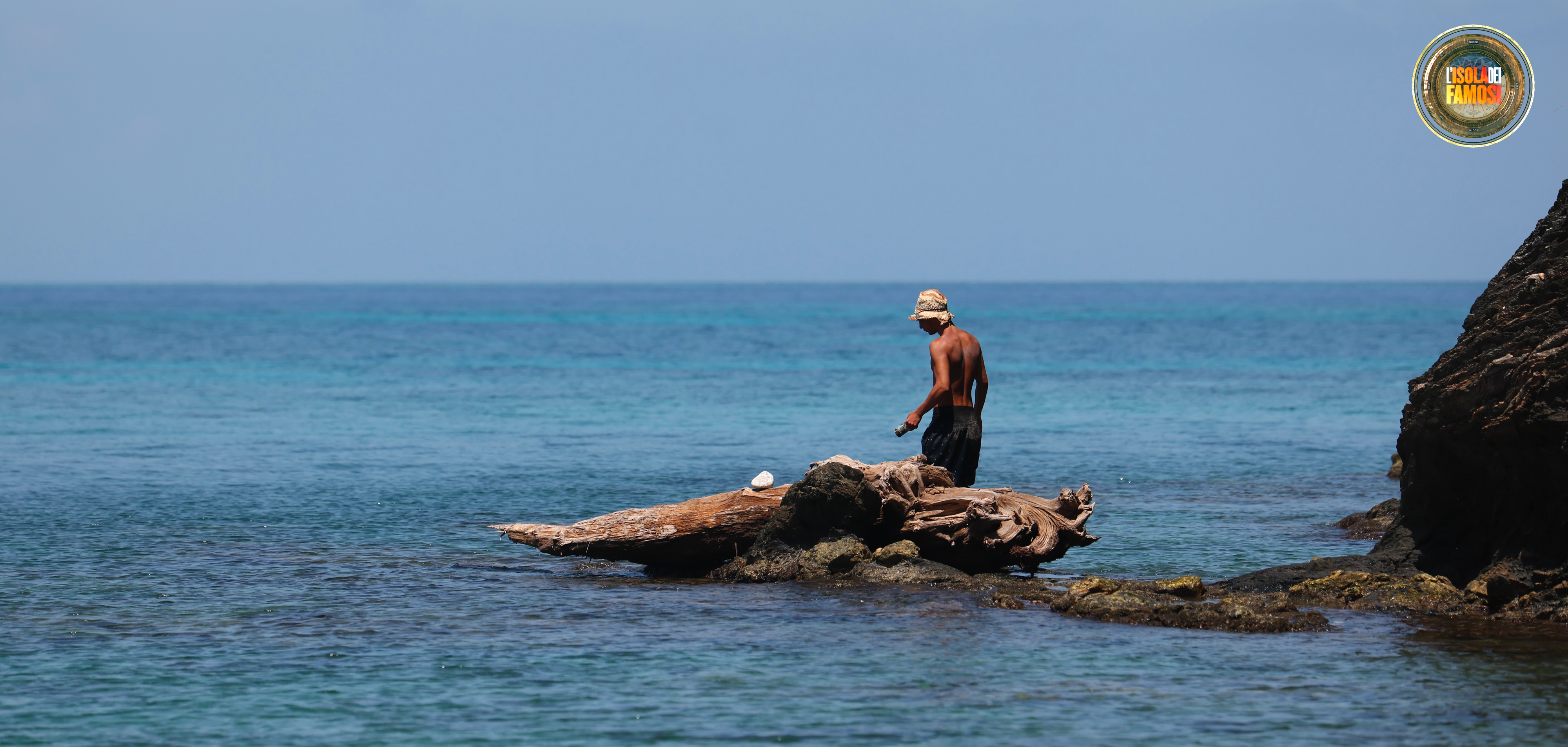 Nunzio pesca da uno scoglio in mezzo al mare.