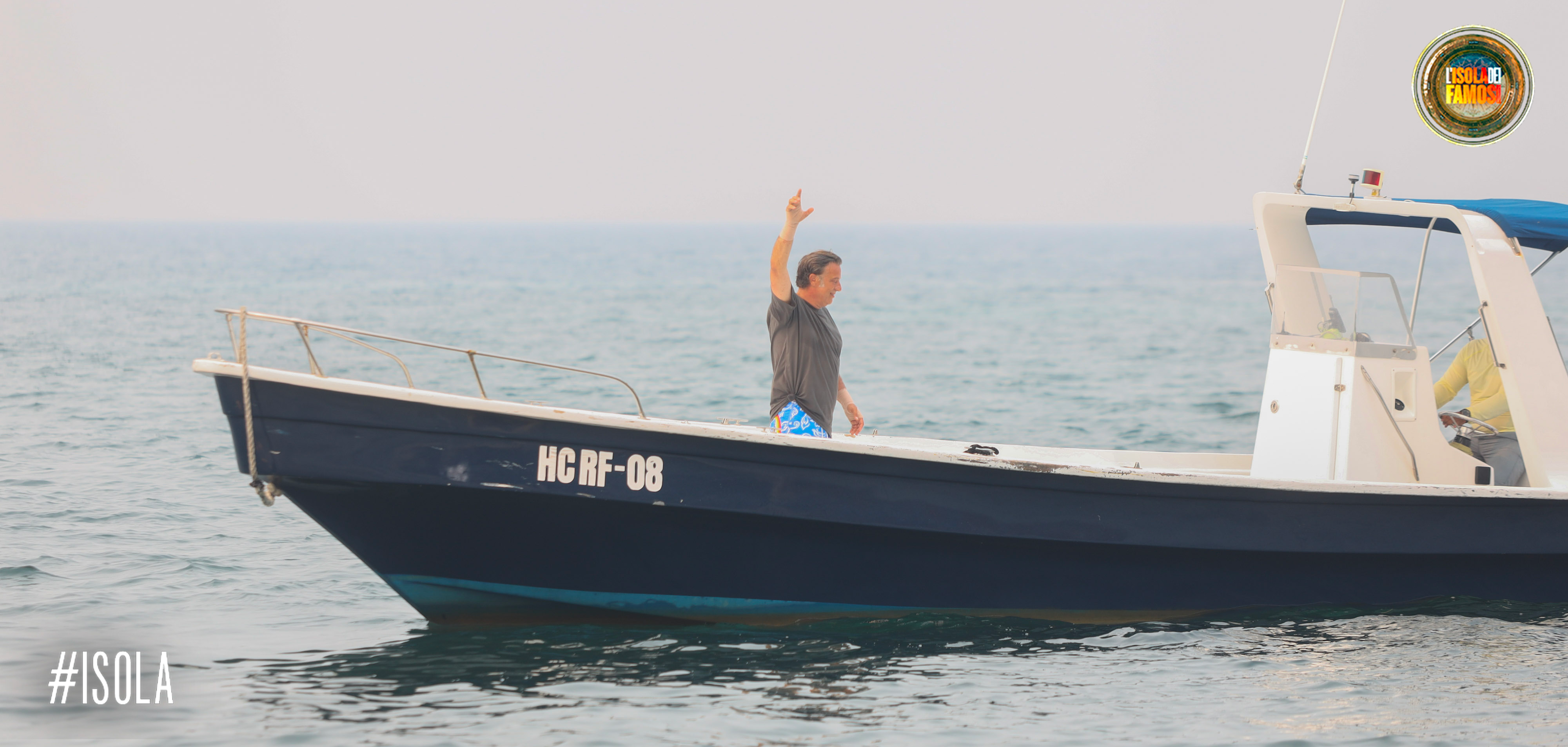 Dario lascia l'Isola salutando i compagni.