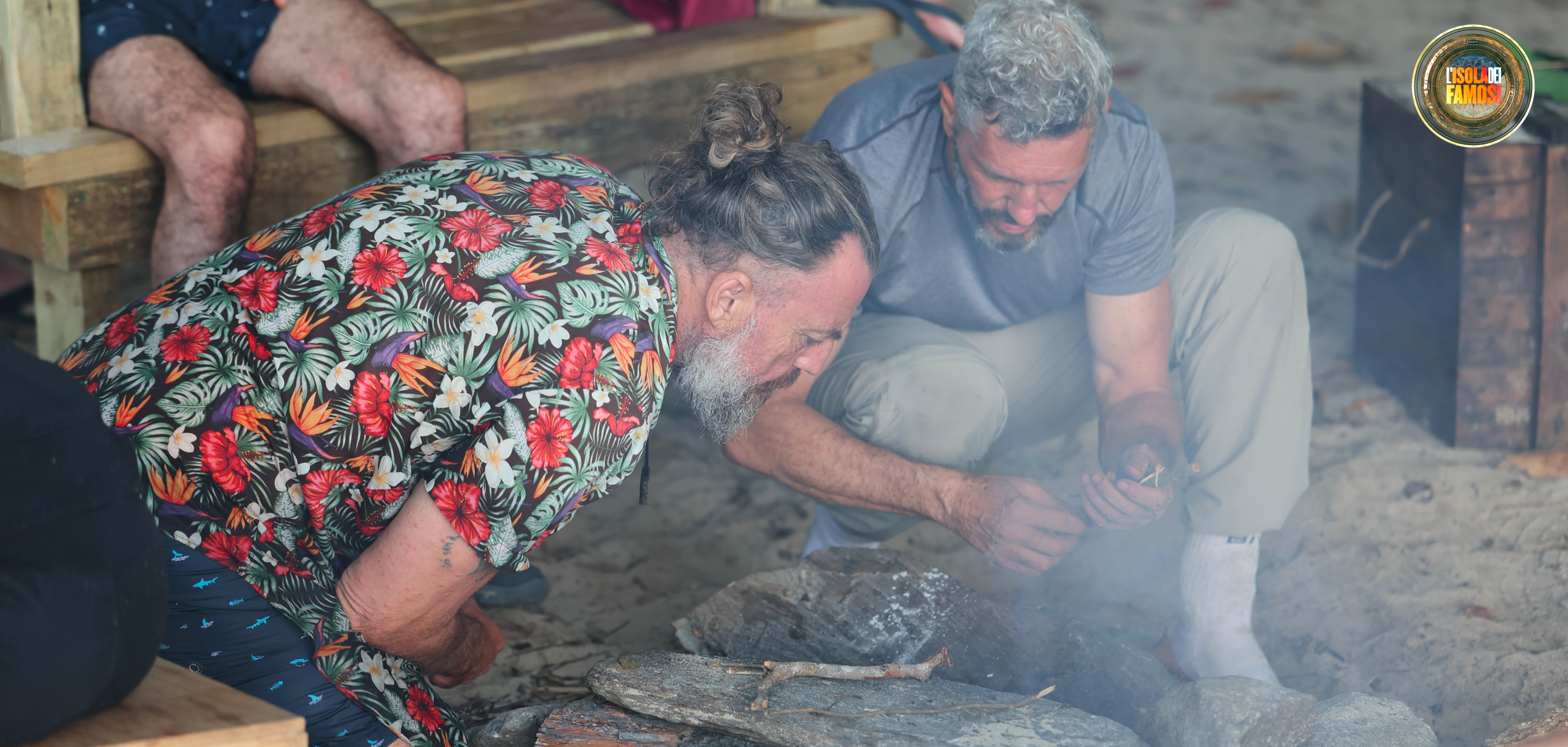 Omar e Mirko alimentano il fuoco per cucinare l’ultimo riso prima dell’arrivo del provvedimento dello Spirito dell’Isola.