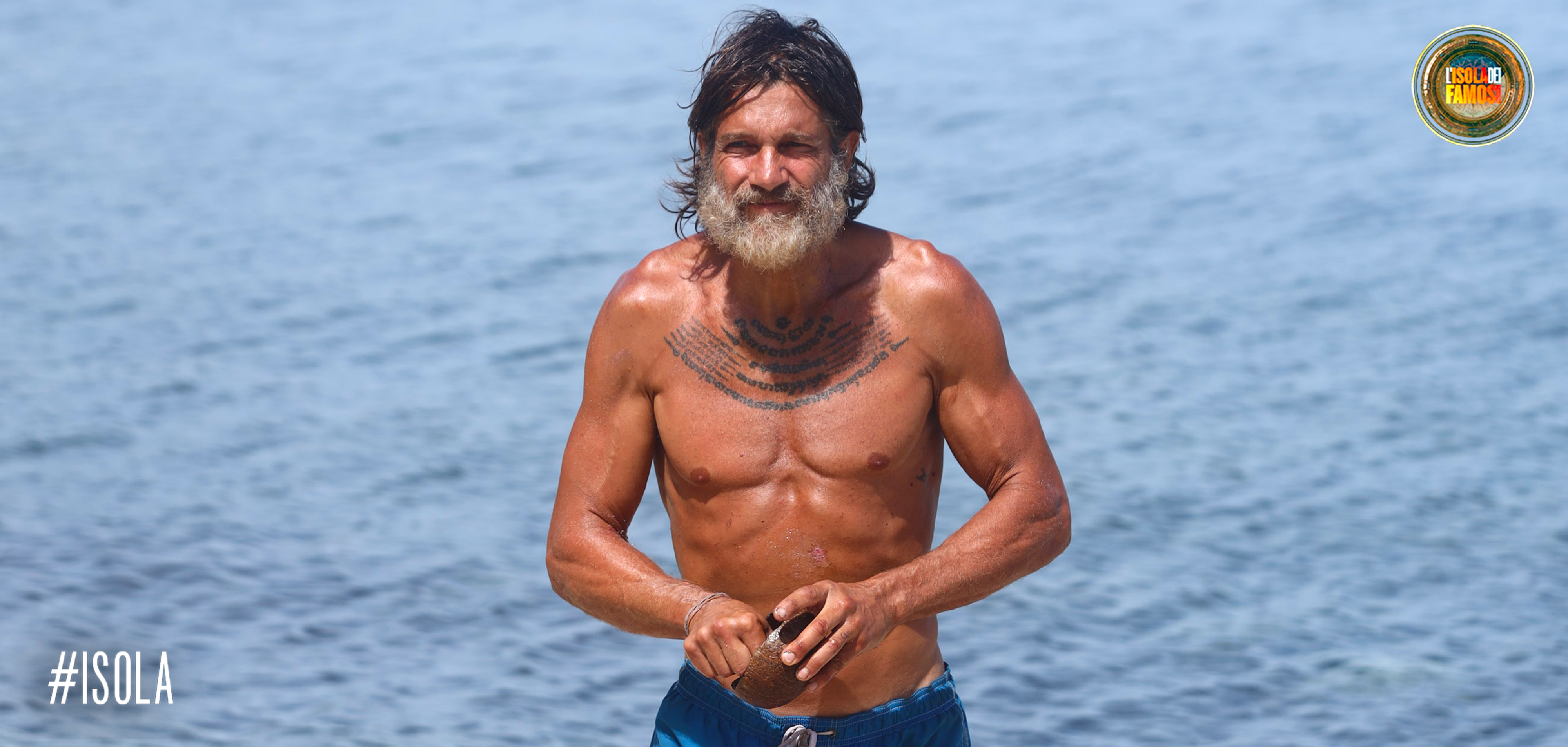 Edoardo Stoppa mentre esce dall'acqua con il suo cocco.