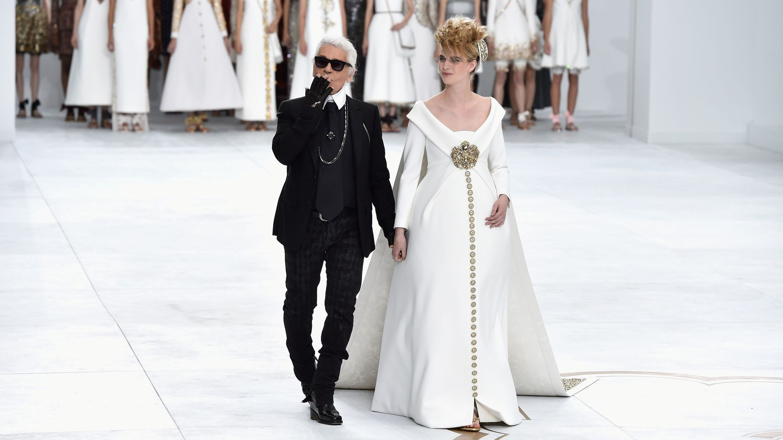 Lo stilista Karl Lagerfeld e Ashleigh Good ringraziano il pubblico per gli applausi al termine della sfilata Chanel durante la Haute Couture parigina dell’ Autunno/Inverno 2014-2015 - Credits: Getty Images