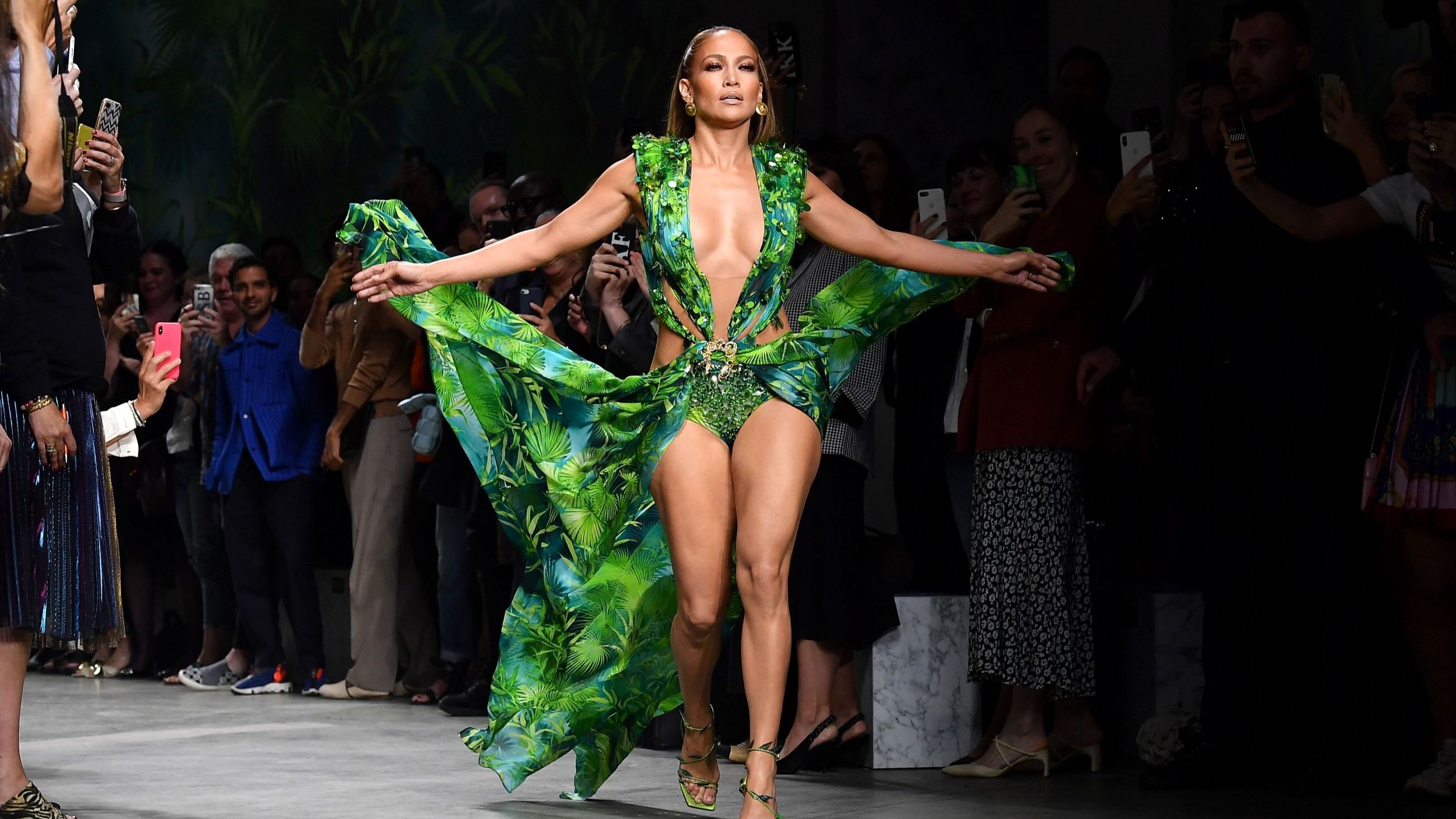 Jennifer Lopez sfila per Versace alla Milano Fashion Week P/E con una nuova versione dell’abito verde dei Grammy 2000.
Credits: Getty Images
