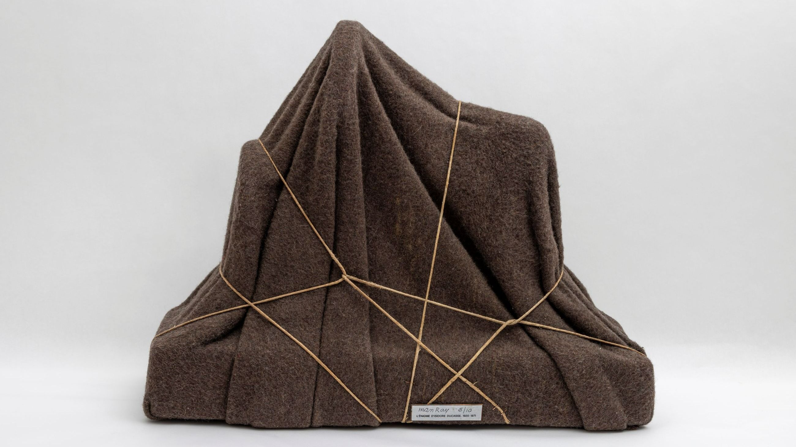 Man Ray. L’Énigme d’Isidore Ducasse, 1920 - 1971. Macchina per cucire avvolta in una coperta. Sewing machine wrapped in a blanket. Edition of 10, Galleria Schwarz, Milan 1971 45 x 58 x 23 cm © Man Ray 2015 Trust, by SIAE 2026 - Courtesy Press Office