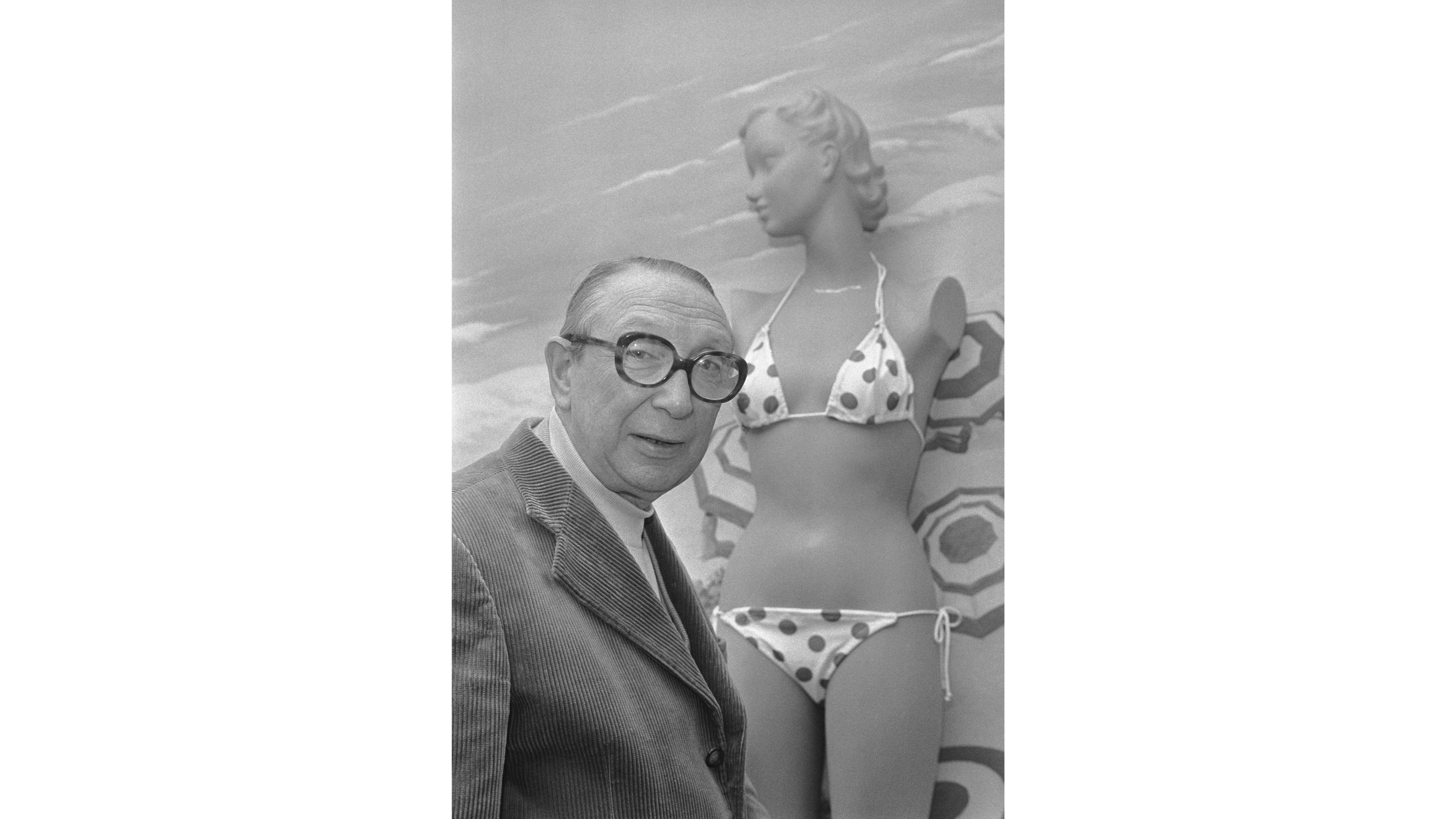 Louis Réard nella sua boutique sull'Avenue de l'Opéra a Parigi con un bikini dell'epoca, 1974 - Credits: Getty Images
