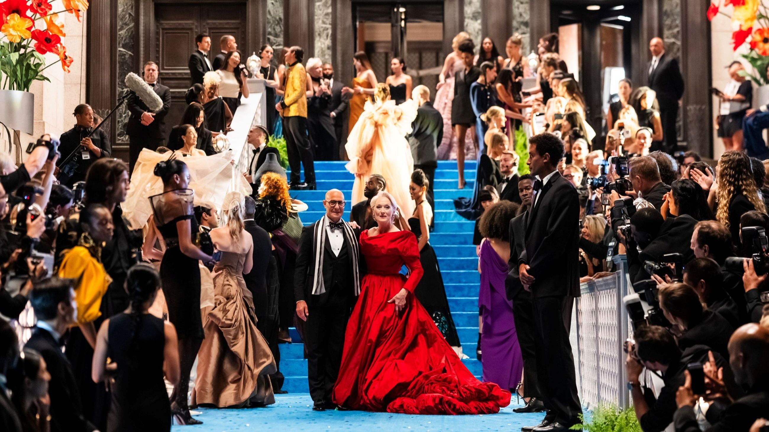 Dal film “Il Diavolo veste Prada 2”: qui Miranda Priestly (Meryl Streep) sfoggia un abito rosso da sogno mentre sorride insieme al fidato amico e collega Nigel Kipling (Stanley Tucci) - Credits: Getty Images