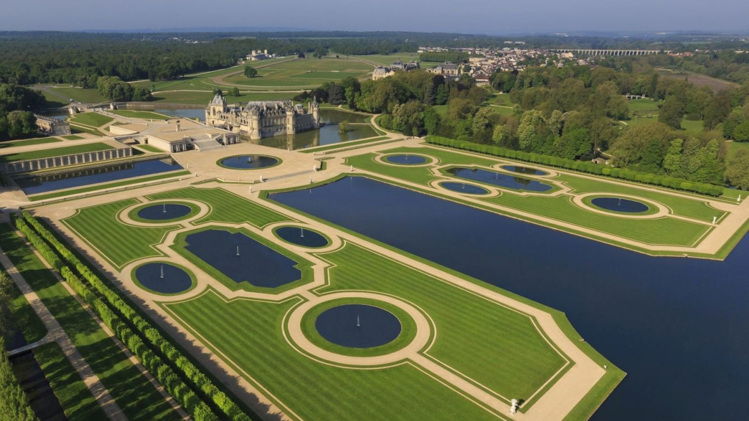 Il Castello di Chantilly visto dall’alto in tutta la sua grandezza. Spiccano i giardini alla francese - Credits: www.aubergedujeudepaumechantilly.fr