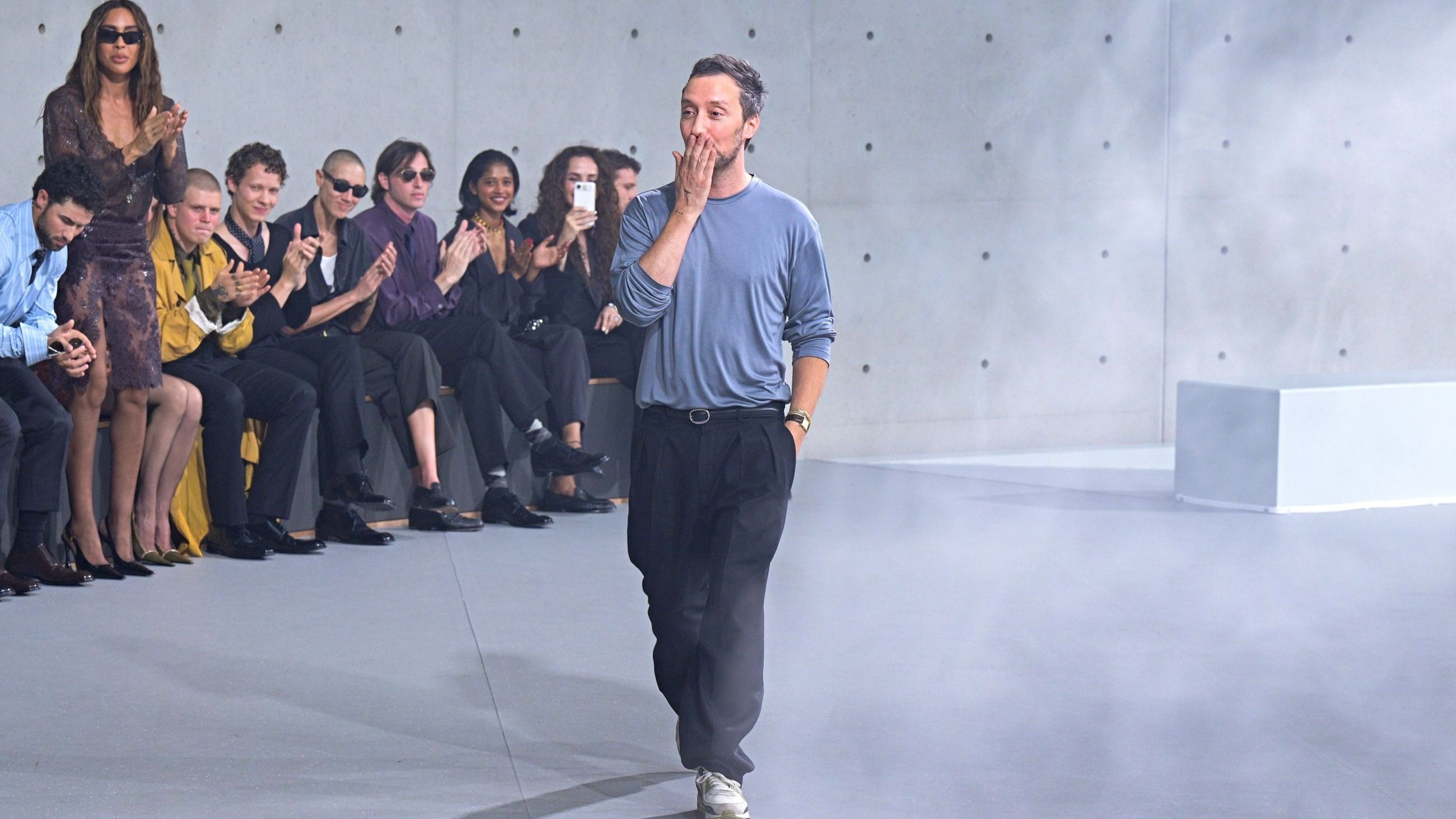 Lo stilista Anthony Vaccarello saluta il pubblico in passerella al termine della sfilata della collezione uomo Primavera/Estate 2027 di Saint Laurent - Credits Getty Images