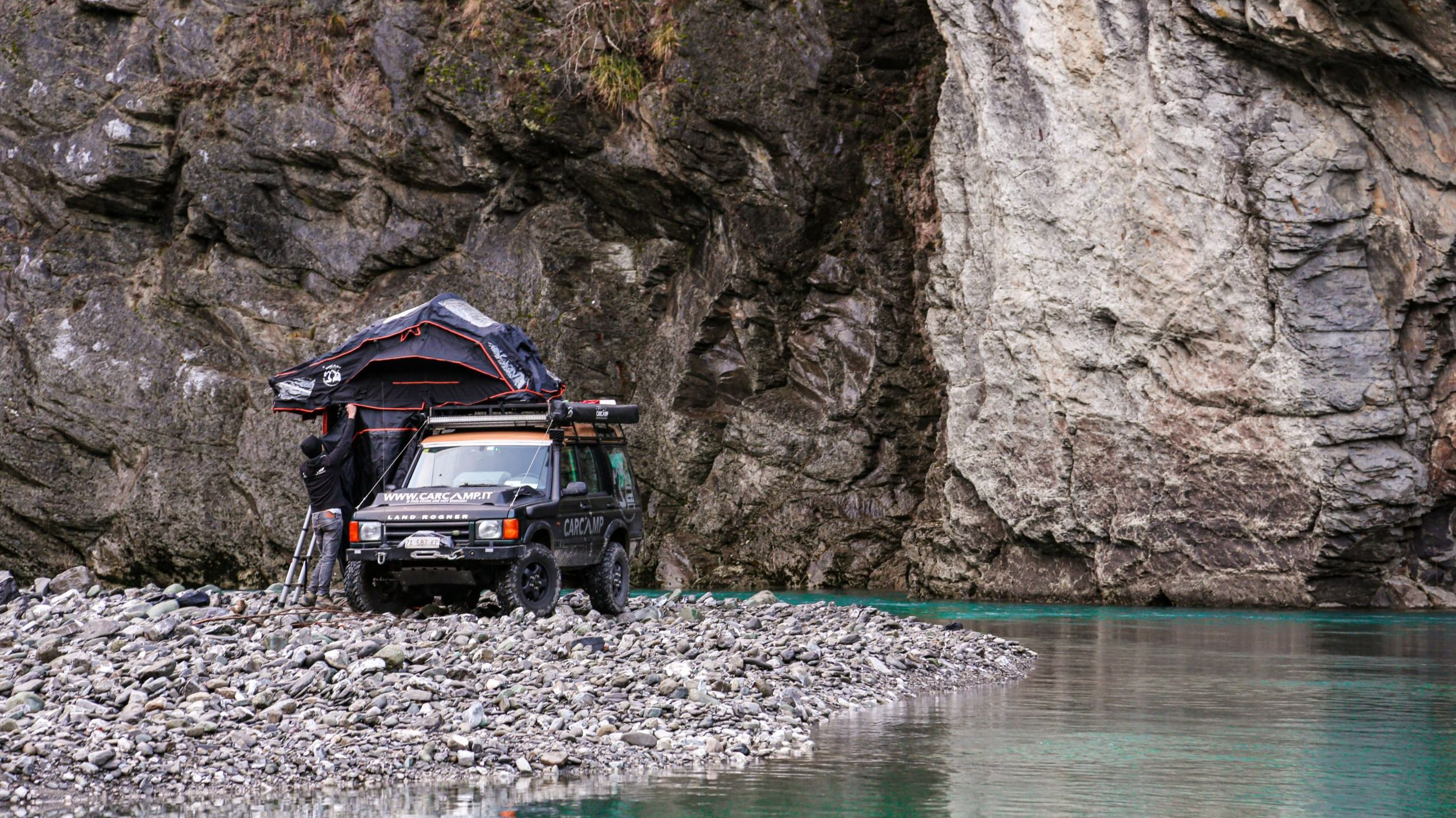 Tra roccia e acqua turchese, le tende, i tendalini e gli annex trasformano la sosta in rifugio, fondendo avventura e comfort in perfetto equilibrio naturale - Crediti CarCamp 