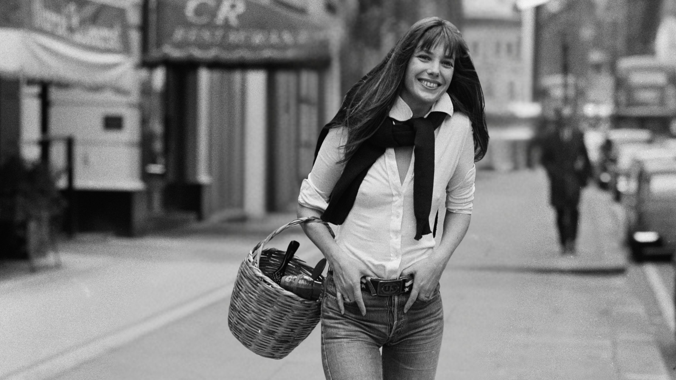 Jane Birkin indossa una camicia bianca, un paio di jeans e un cestino di vimini appeso al braccio destro, Londra, 1973 - Credits Getty Images