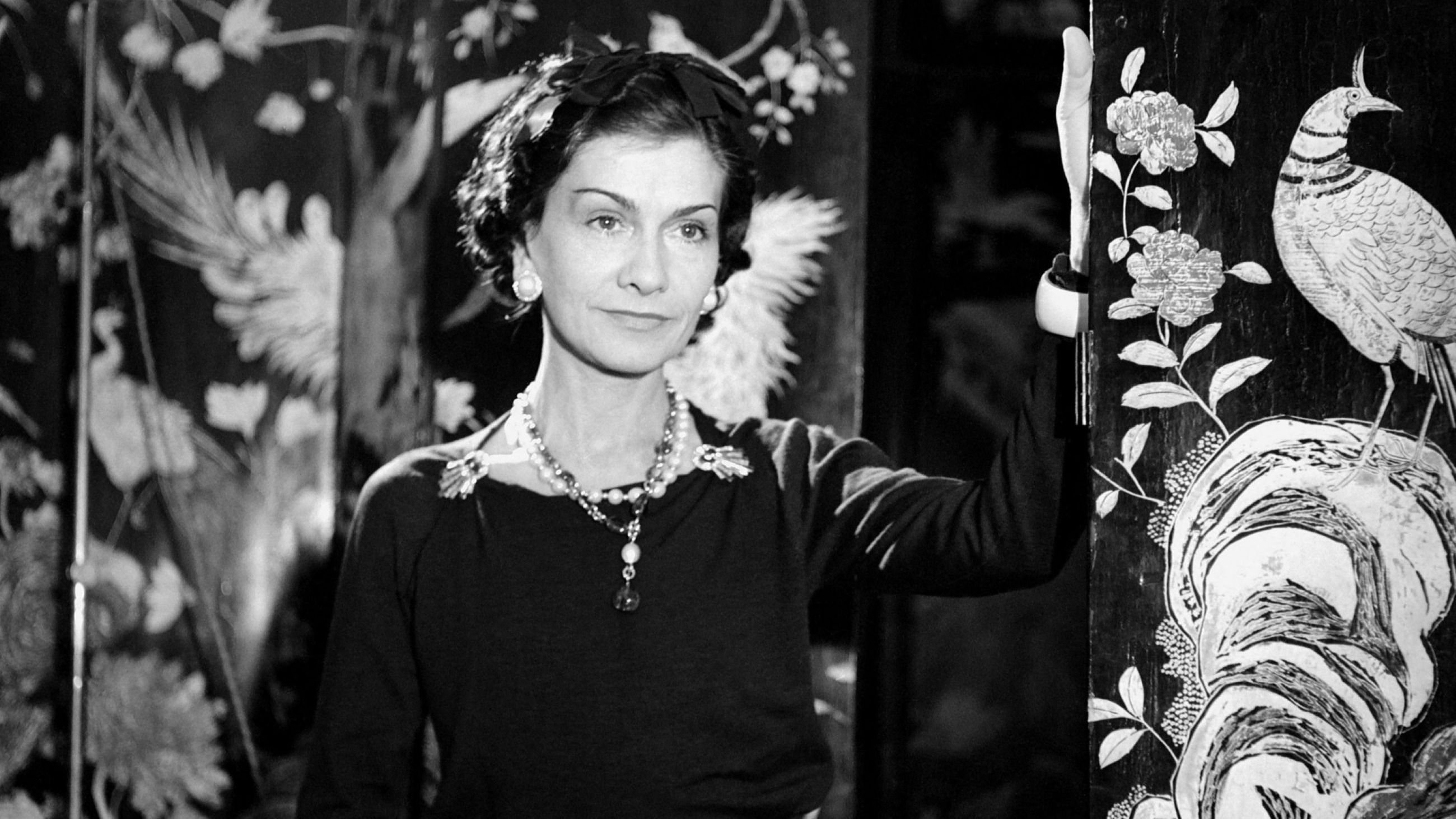 Gabrielle Chanel allo specchio vestita con un abito nero, colore ispirato a quello indossato dalle suore dell'orfanotrofio in cui trascorse alcuni anni della sua giovinezza - Credits: Ufficio Stampa