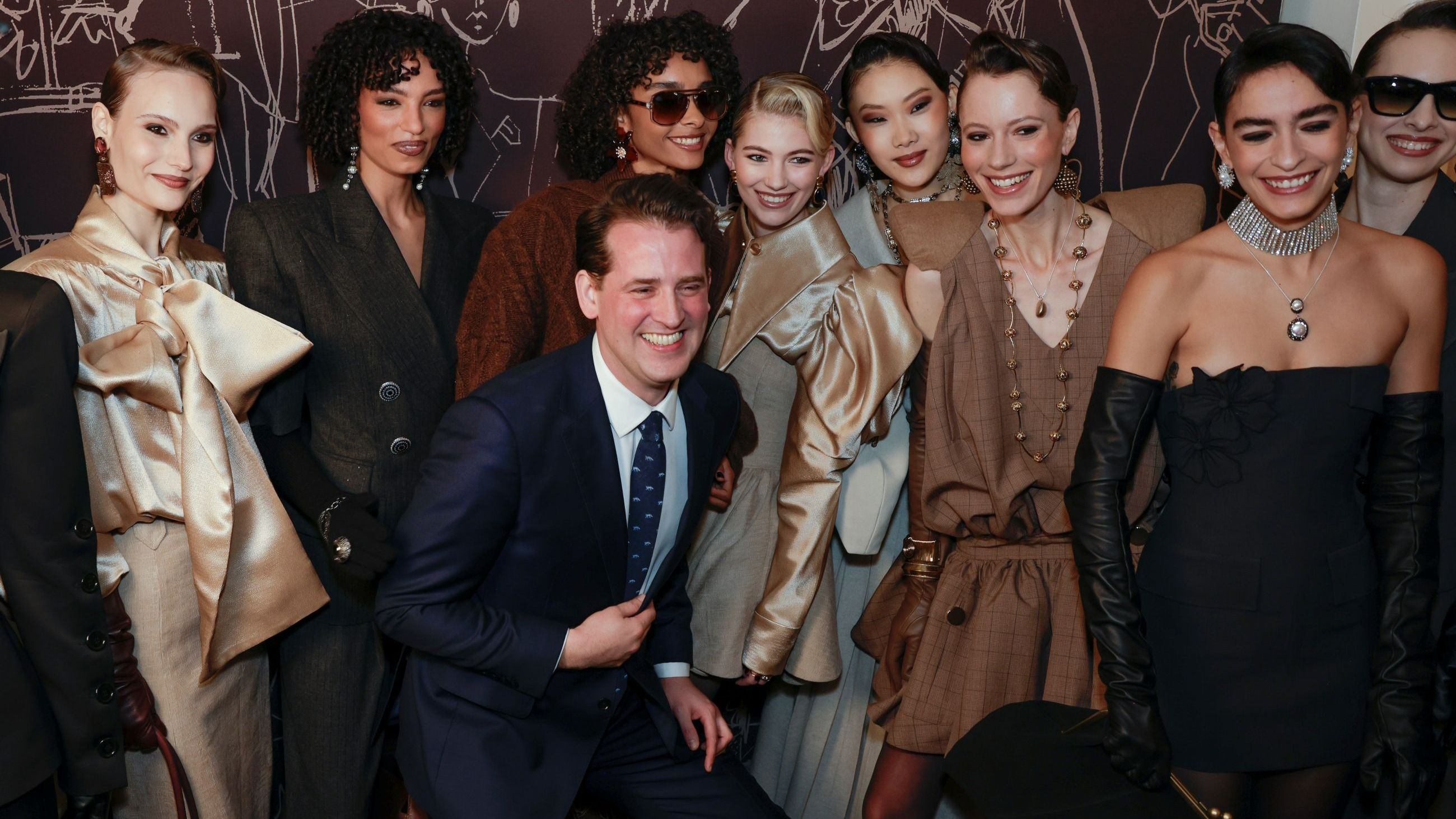 William Costelloe posa con le modelle nel backstage della sfilata di Paul Costelloe durante la London Fashion Week 2026 - Credits Getty Images
