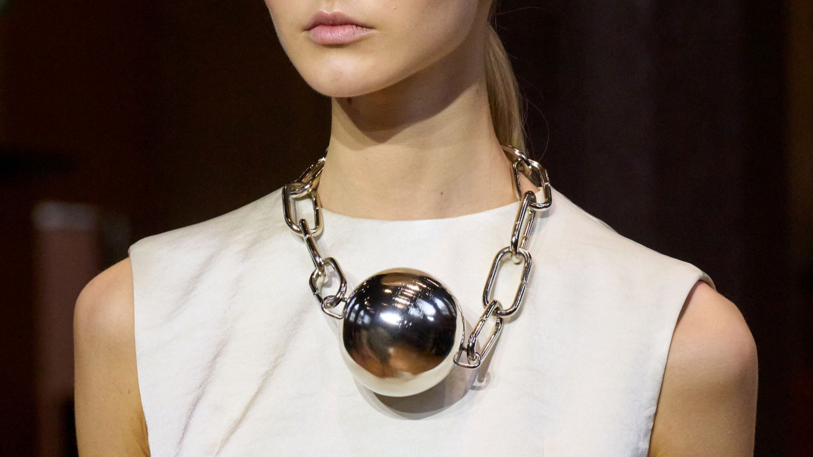 Una collana argentata “a catena” con maglie larghe e rettangolari e una grossa sfera al centro che fa brillare il décolleté; Leroy, sfilata FW2526 - Credits: Launchmetrics.com/Spotlight