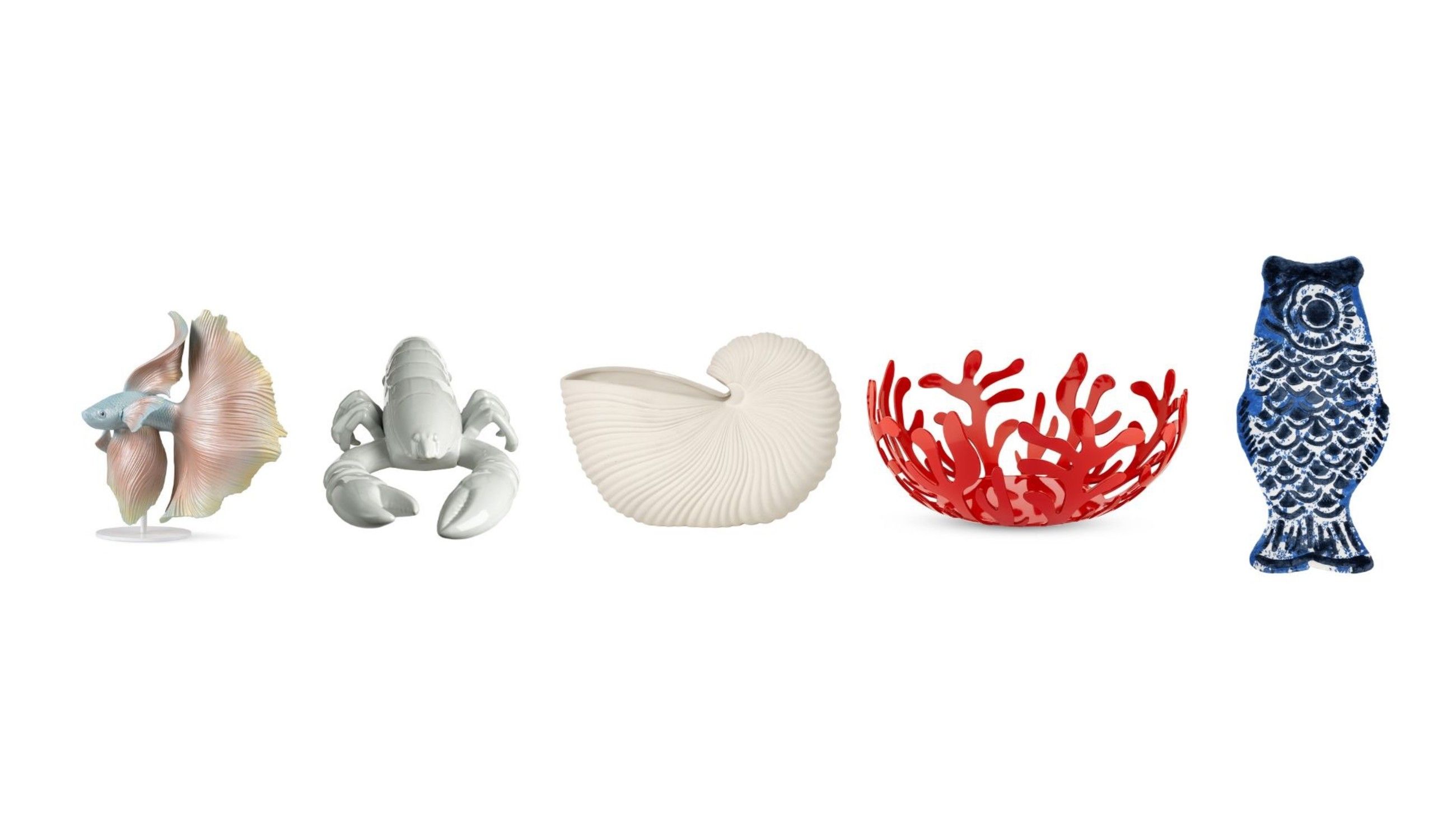 Da sinistra: Scultura Betta Fish, Lladró; Astice in ceramica, Pols Potten; Vaso Nautilus, Ferm Living; Fruttiera Mediterraneo, Alessi; Tappeto Fish, Illulian - Courtesy Press Office