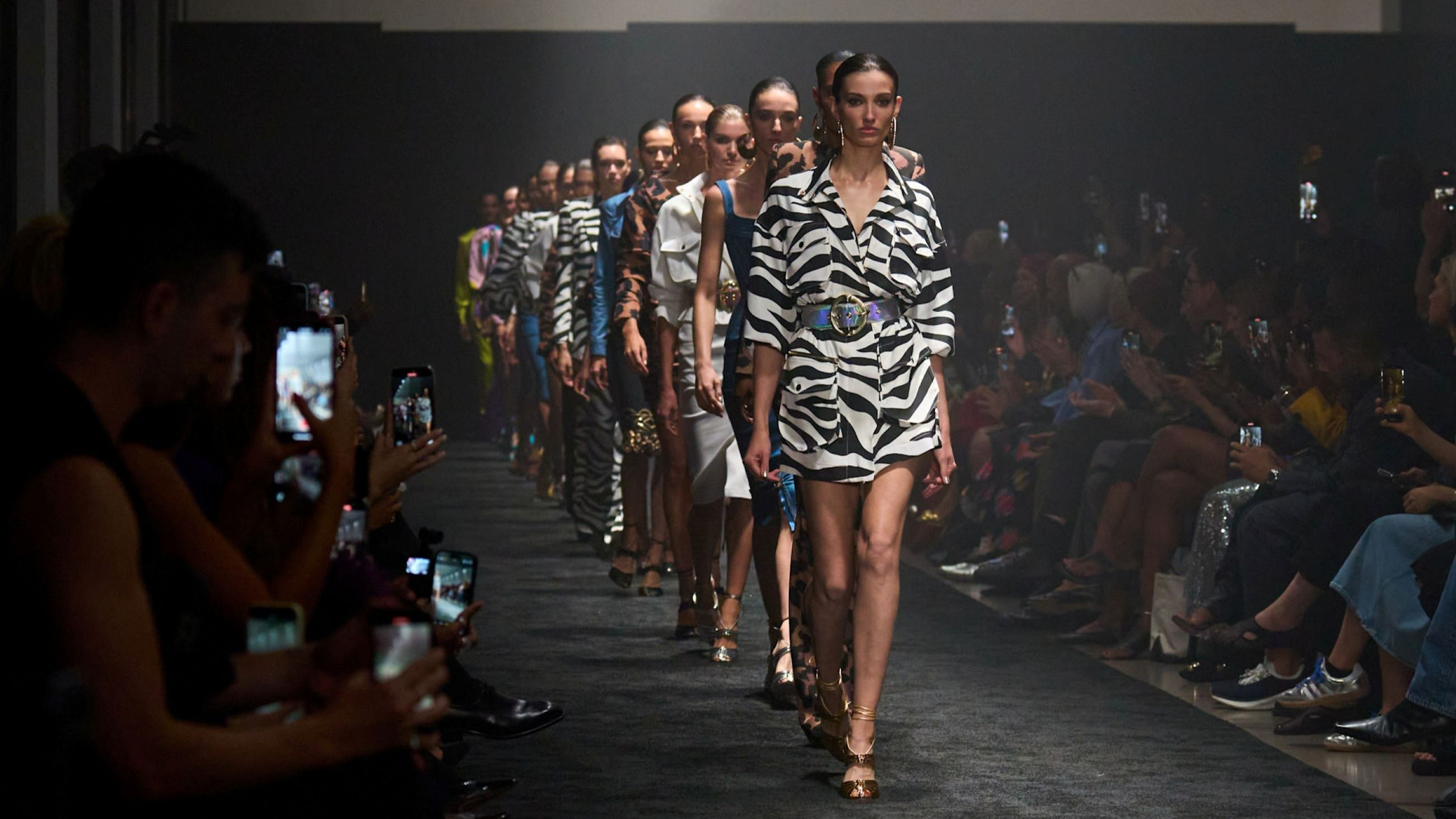 Sergio Hudson PE26: il look che apre la sfilata è un trench zebrato, indossato chiuso in modalità miniabito - Credits: Launchmetrics.com/Spotlight