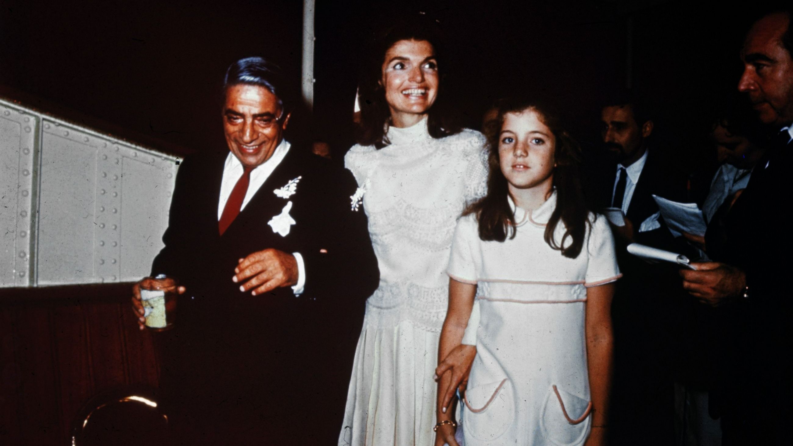 Con tracce di coriandoli addosso, il signor e la signora Aristotle Onassis (Jackie Kennedy) sono ritratti durante il loro matrimonio del 20 ottobre sull’isola privata di Onassis. Caroline Kennedy, 10 anni, è in piedi accanto a sua madre - Credits: Getty Images 