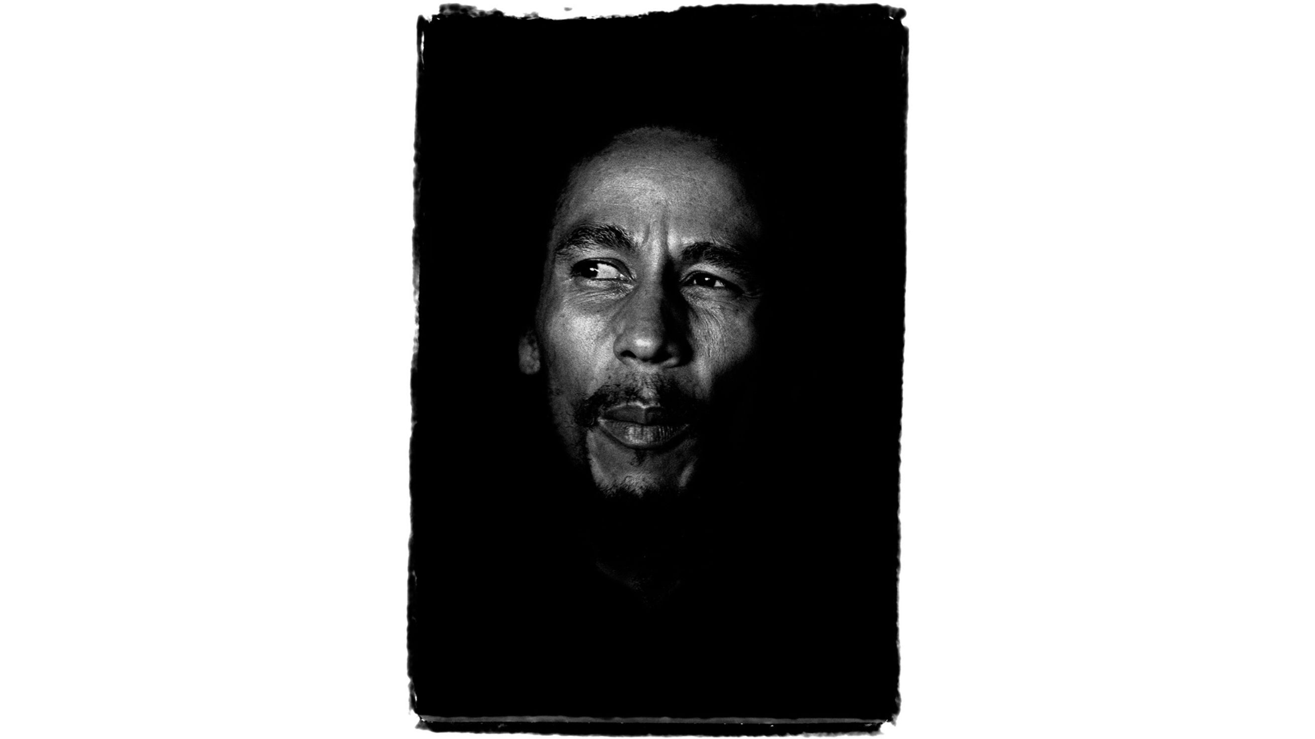Bob Marley, fotografato da Guido Harari: il volto emerge dall’ombra come un canto che non si spegne mai – Crediti: Guido Harari/Wall of Sound Gallery