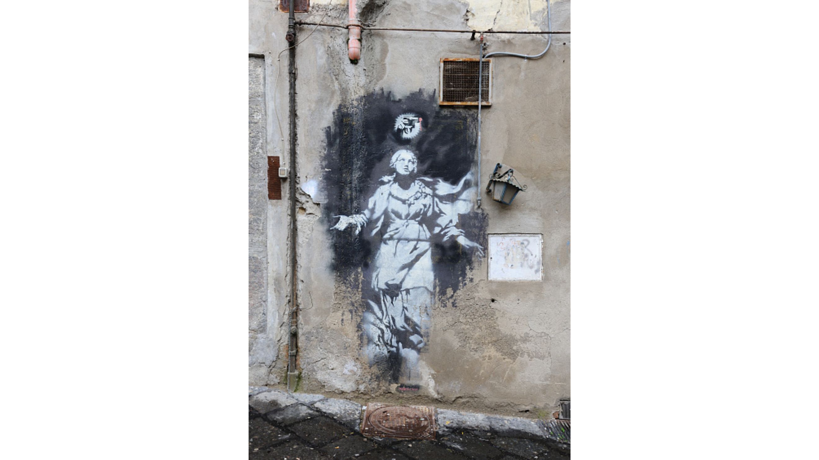Murale nel centro storico di Napoli, fotografato il 10 gennaio 2015. L’opera attribuita a Banksy, tra le più note della città, riflette la vitalità della street art partenopea lungo le vie del centro antico - Credits Getty Images
