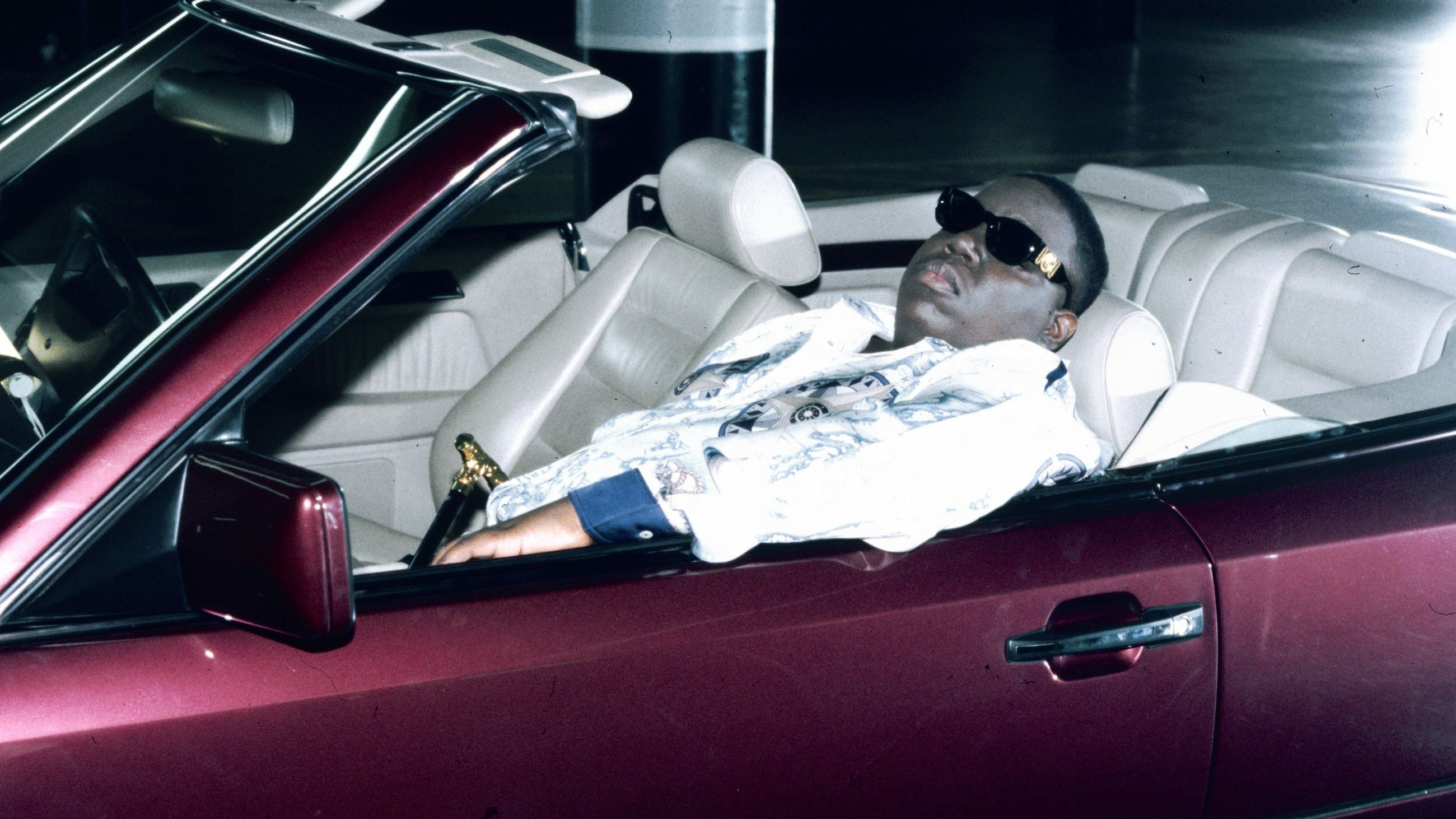 Il rapper americano Notorious BIG seduto su una decappottabile sul set del suo video musicale “Hypnotize”, 1997 - Credits Getty Images