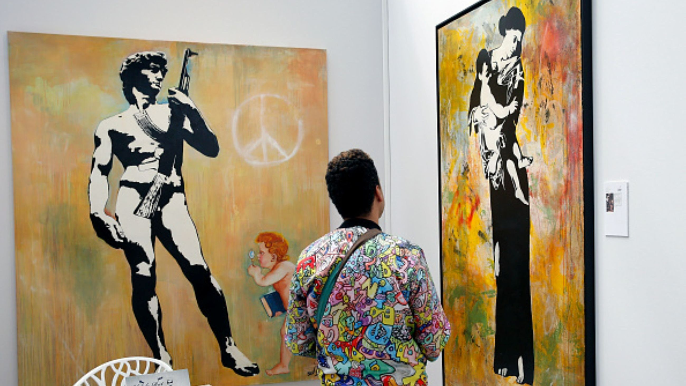 Un visitatore osserva le opere di Blek le Rat durante la press preview di Art Paris Art Fair 2018 al Grand Palais, il 4 aprile 2018. L’edizione riuniva 142 gallerie da 23 Paesi - Credits Getty Images