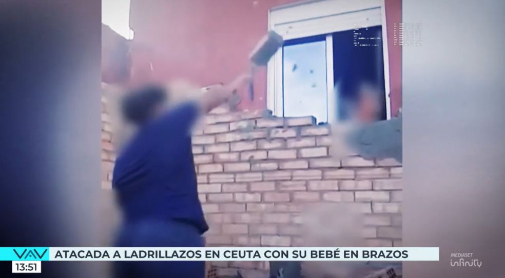 El momento en el que un joven lanza un ladrillo a la mujer con su bebé en brazos