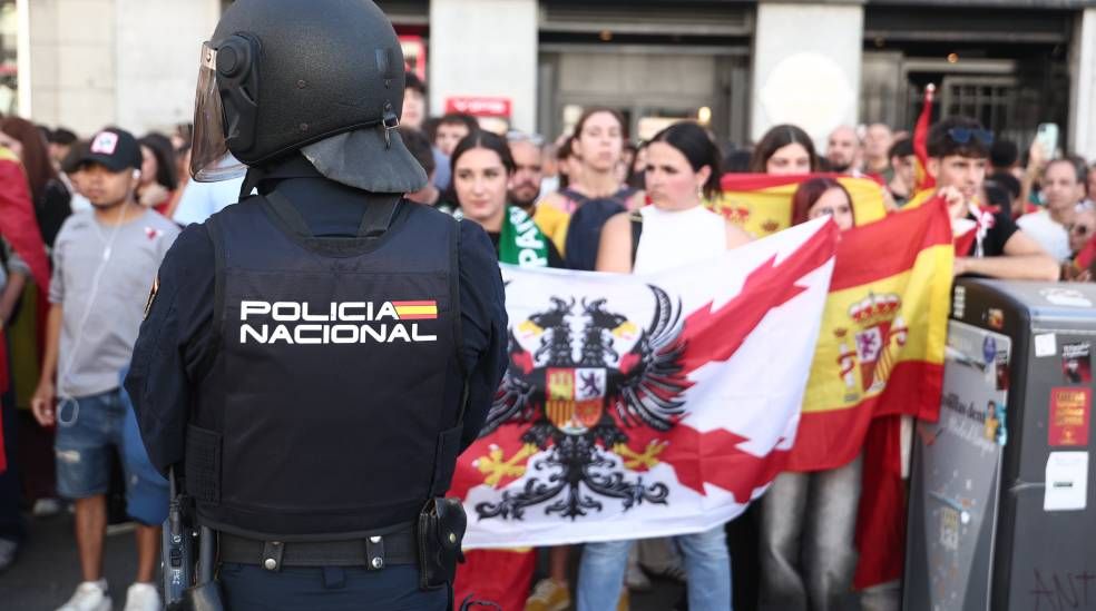 La Policía, vigilando la tensión en la Puerta del Sol entre participantes del desfile militar y los acampados por la crisis de la vivienda.