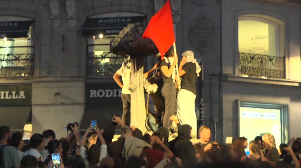 Varios manifestantes subidos al monumento del Oso y el Madroño en la Puerta del Sol