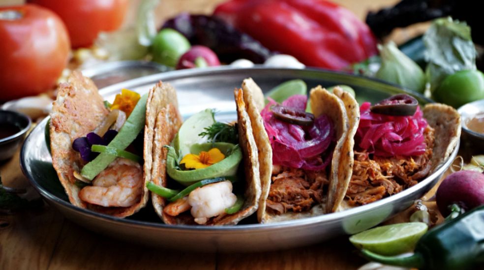 Un taco realmente es una tortilla, generalmente de maíz, que envuelve o sostiene un relleno