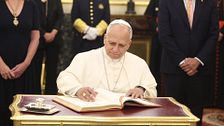 El momento en el que el papa León XIV firma el libro de honor del Congreso