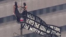 Dos personas escalan el Empire State de Nueva York y despliegan una pancarta en protesta por la paz