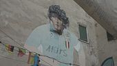Turisti in festa ai Quartieri Spagnoli, telo rimosso dal murale di Maradona