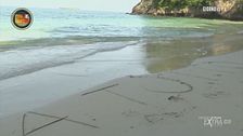 Mirko Frezza scrive una frase sulla sabbia